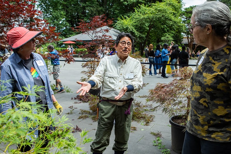 Sadafumi (Sada) Uchiyama conversing with guests with maple trees.