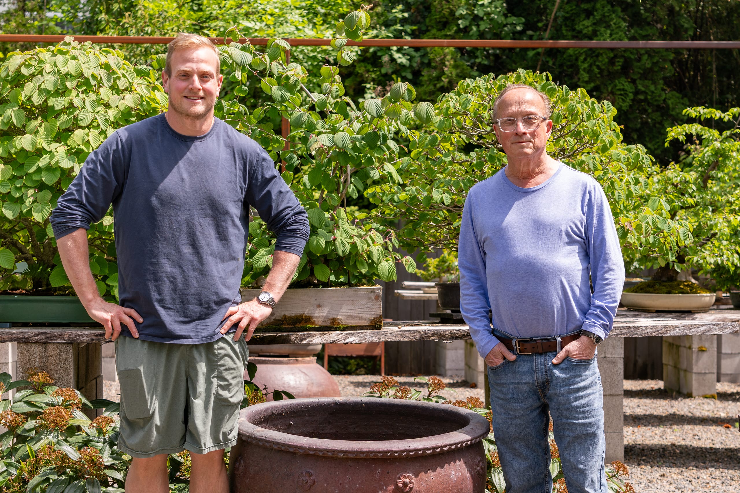 two men standing next to a large pot