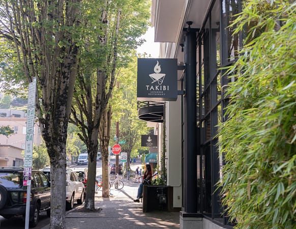 a tree-lined sidewalk outside a restaurant
