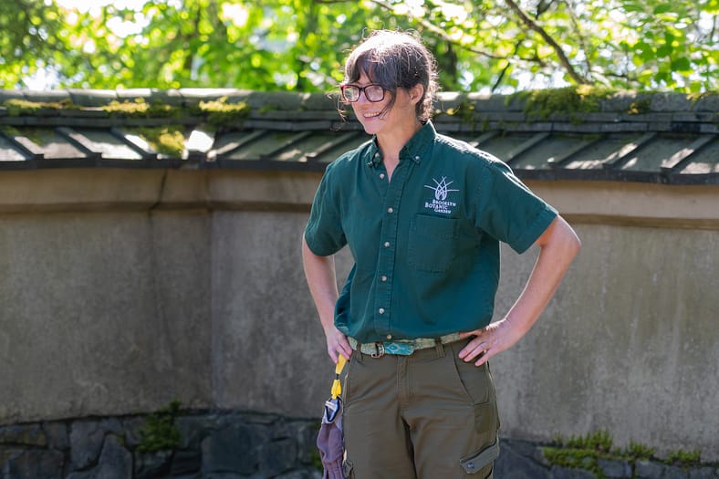 A woman smiles with her hands on her hips