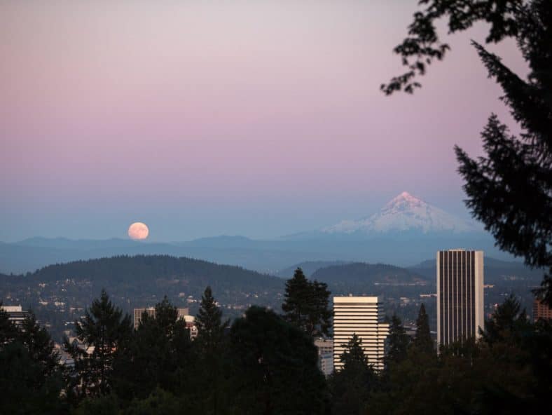 The view from Portland Japanese Garden's East veranda showing the moon rising over downtown Portland, Oregon