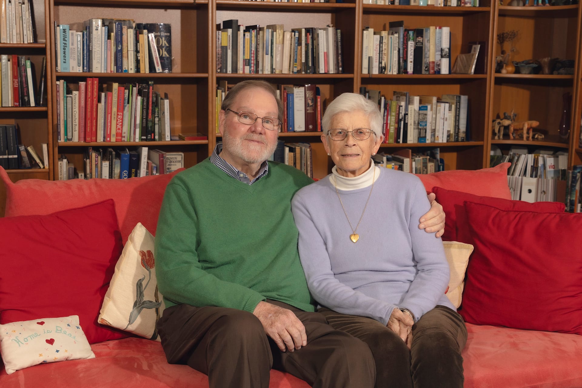 a married couple, man and woman, sitting on a couch in a library