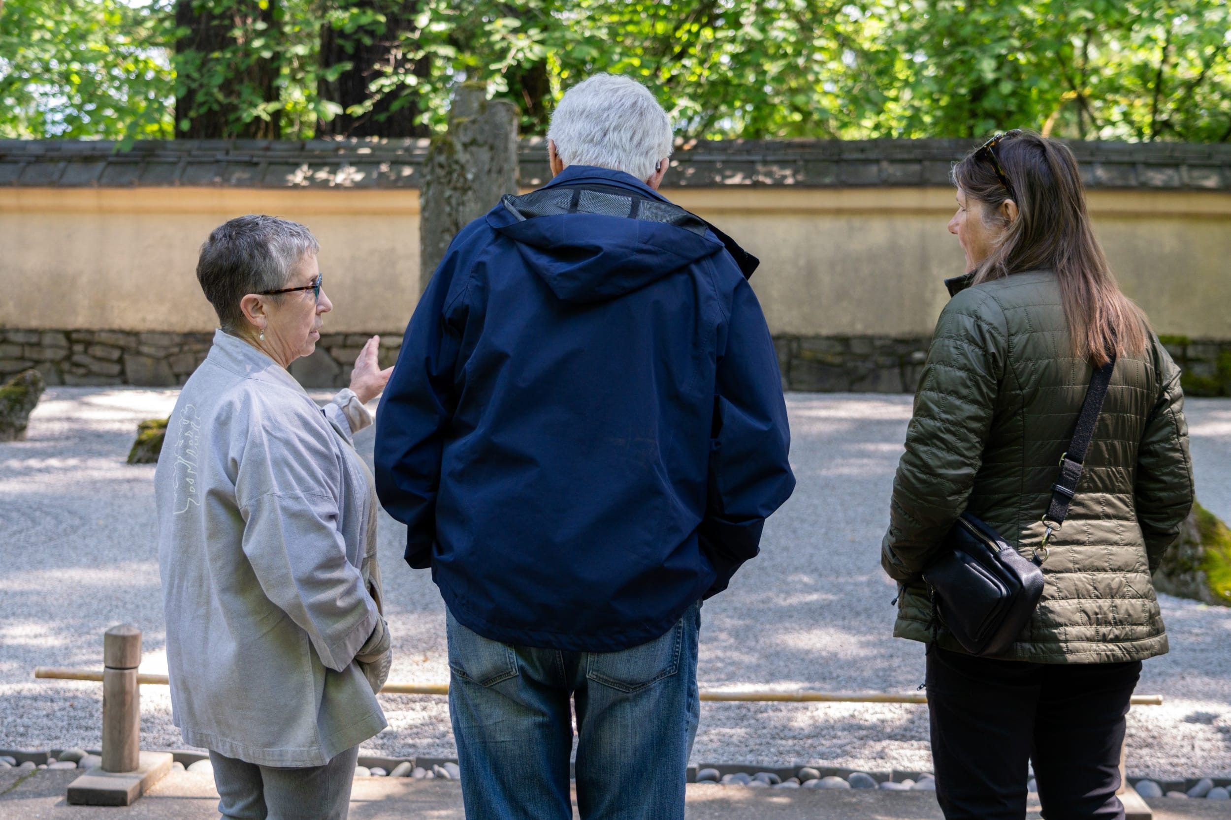 a docent points at a raked gravel garden