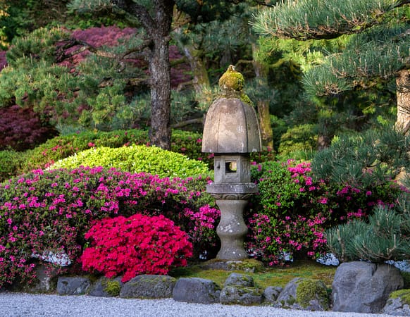 a stone lantern next to flowers