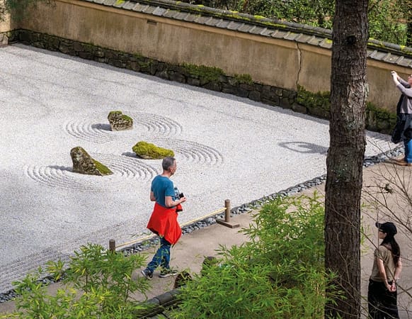 people walking near a raked gravel garden