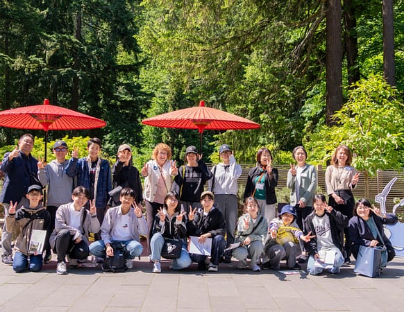 a group of students pose for a camera in a garden
