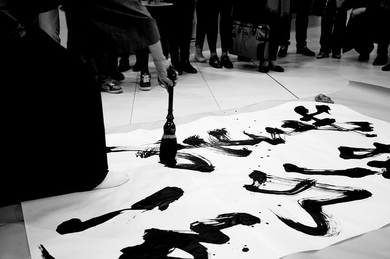 Artist Kihachiro Nishiura working on a large Calligraphy piece