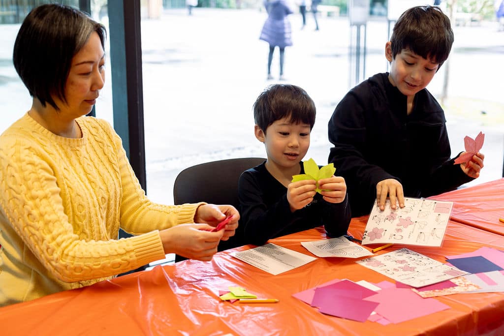 Mom and kids doing origami.