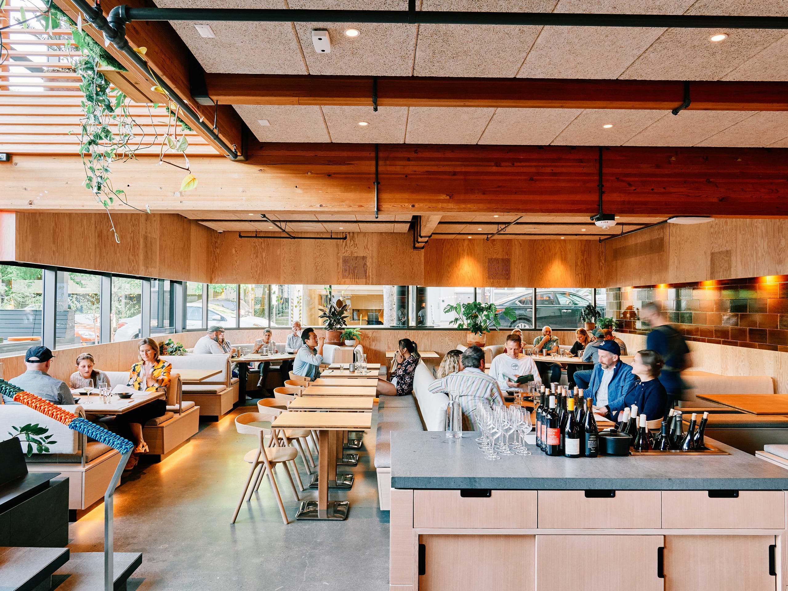 a warm restaurant with wood paneling shows people eating