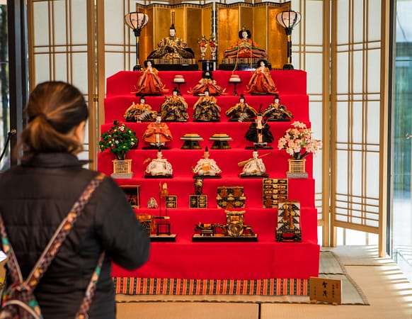 Woman taking photo of the Hina Matsuri display.