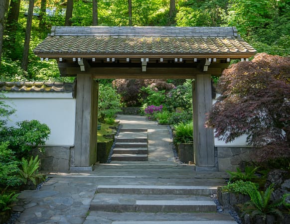 a wooden gate in front of a hillside