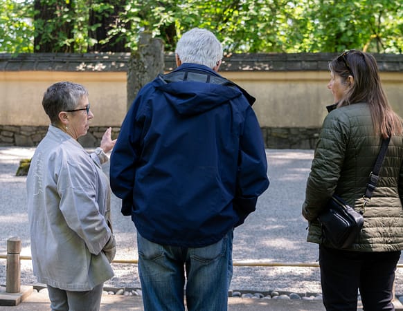 a docent points at a raked gravel garden