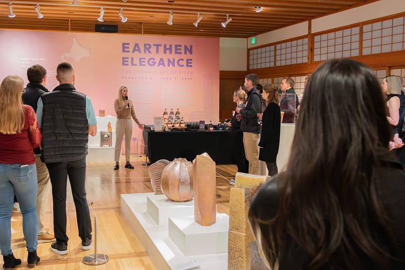 a group watches someone speaking into a microphone