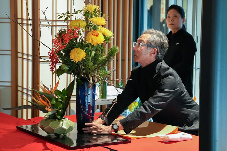 a man looks intensely at flower arrangement