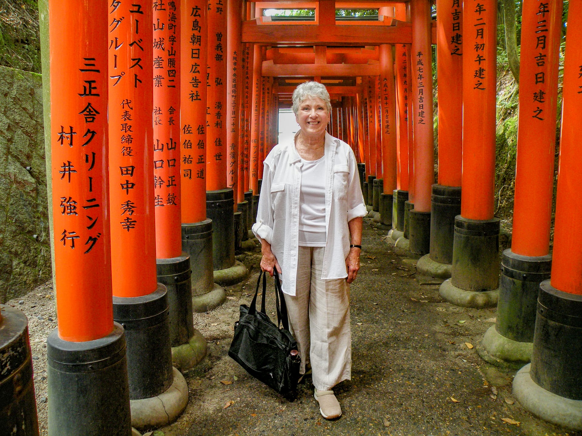 a woman standing next to bright red wooden posts