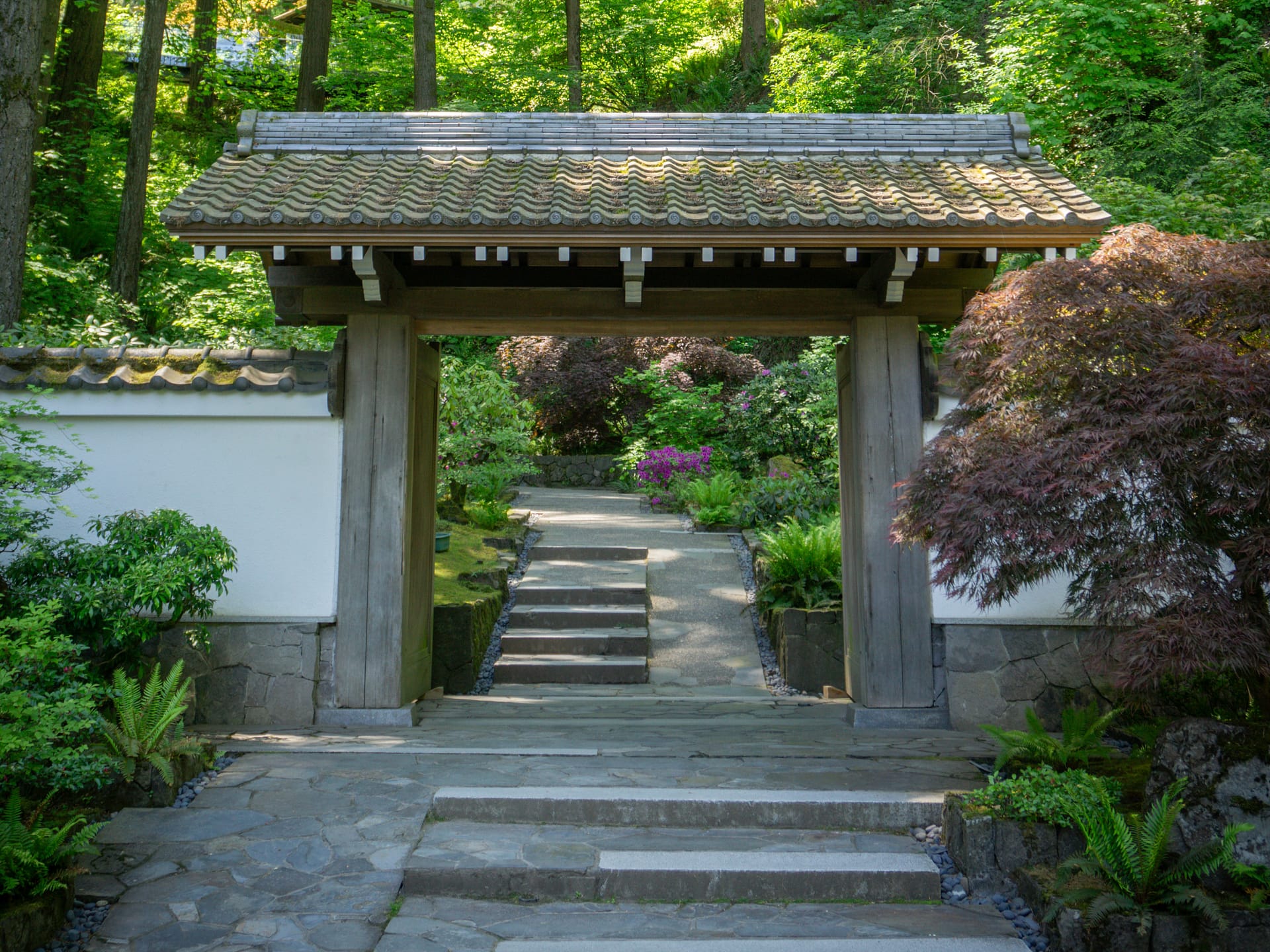 a wooden gate in front of a hillside