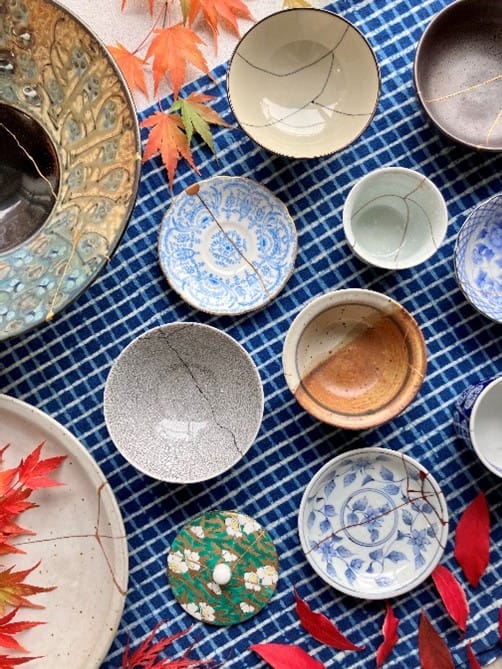 birds eye view of cracked ceramics on a table repaired into whole bowls and plates