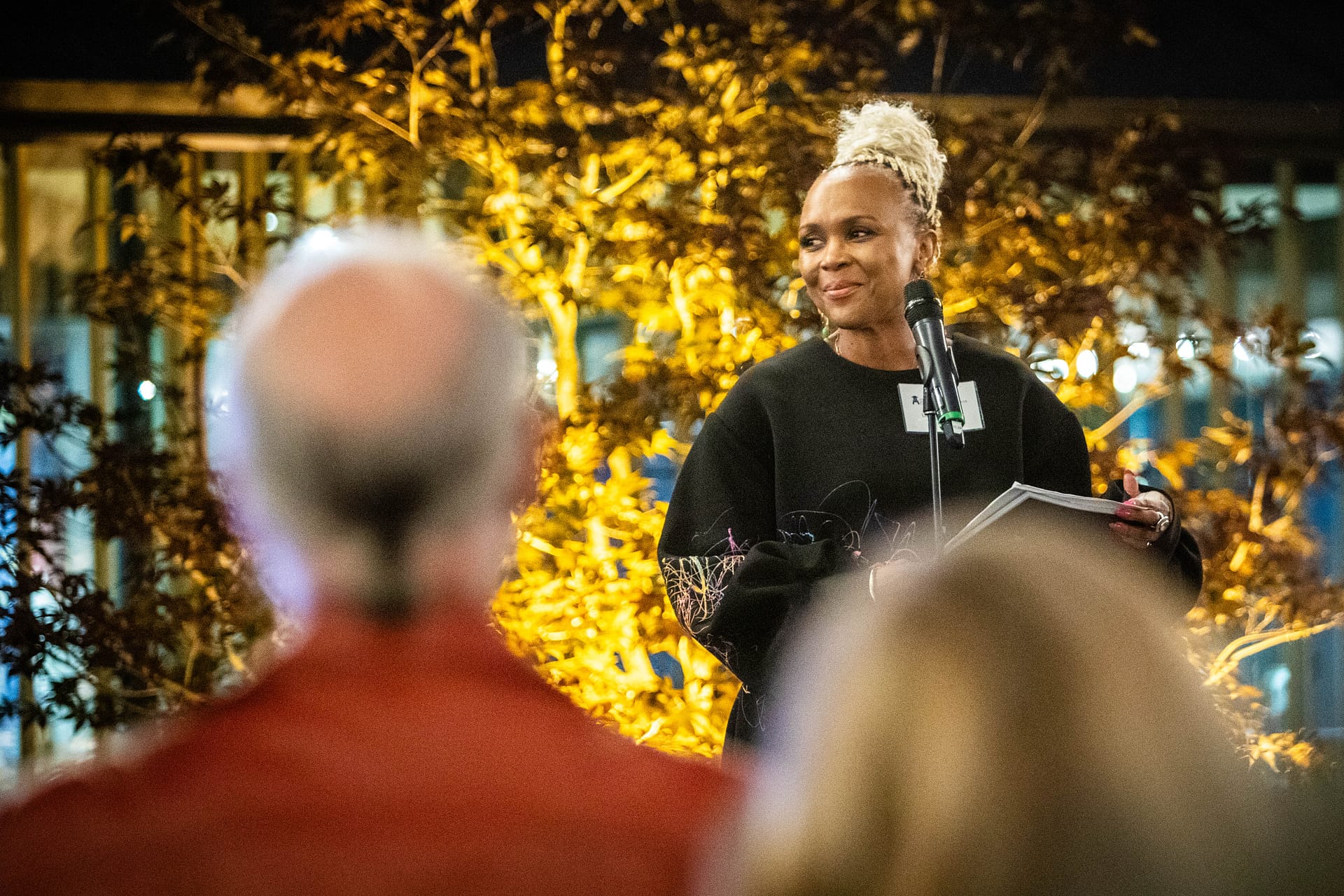 woman standing on stage in front of a microphone
