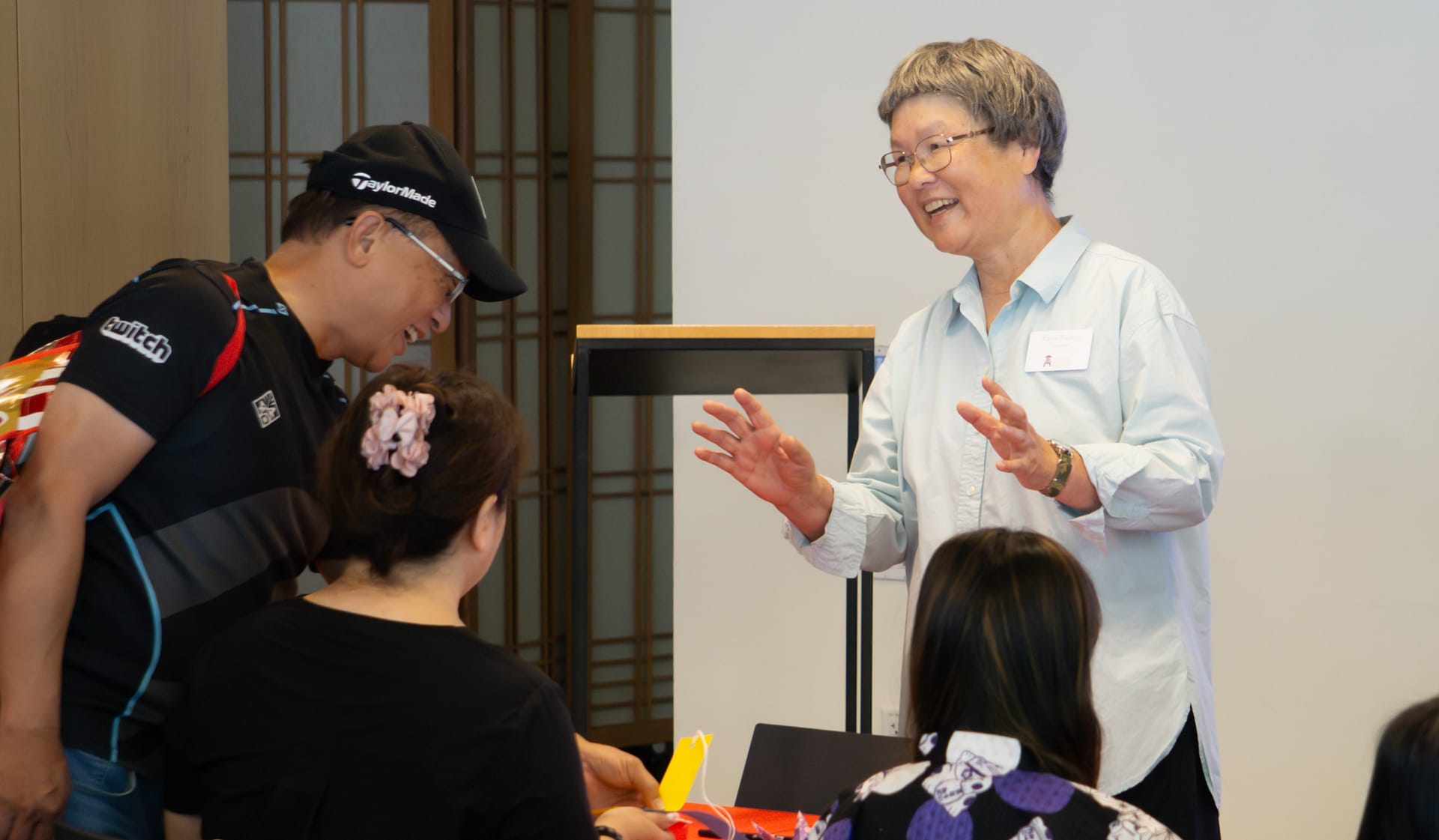 a woman smiles kindly while teaching guests about tanabata
