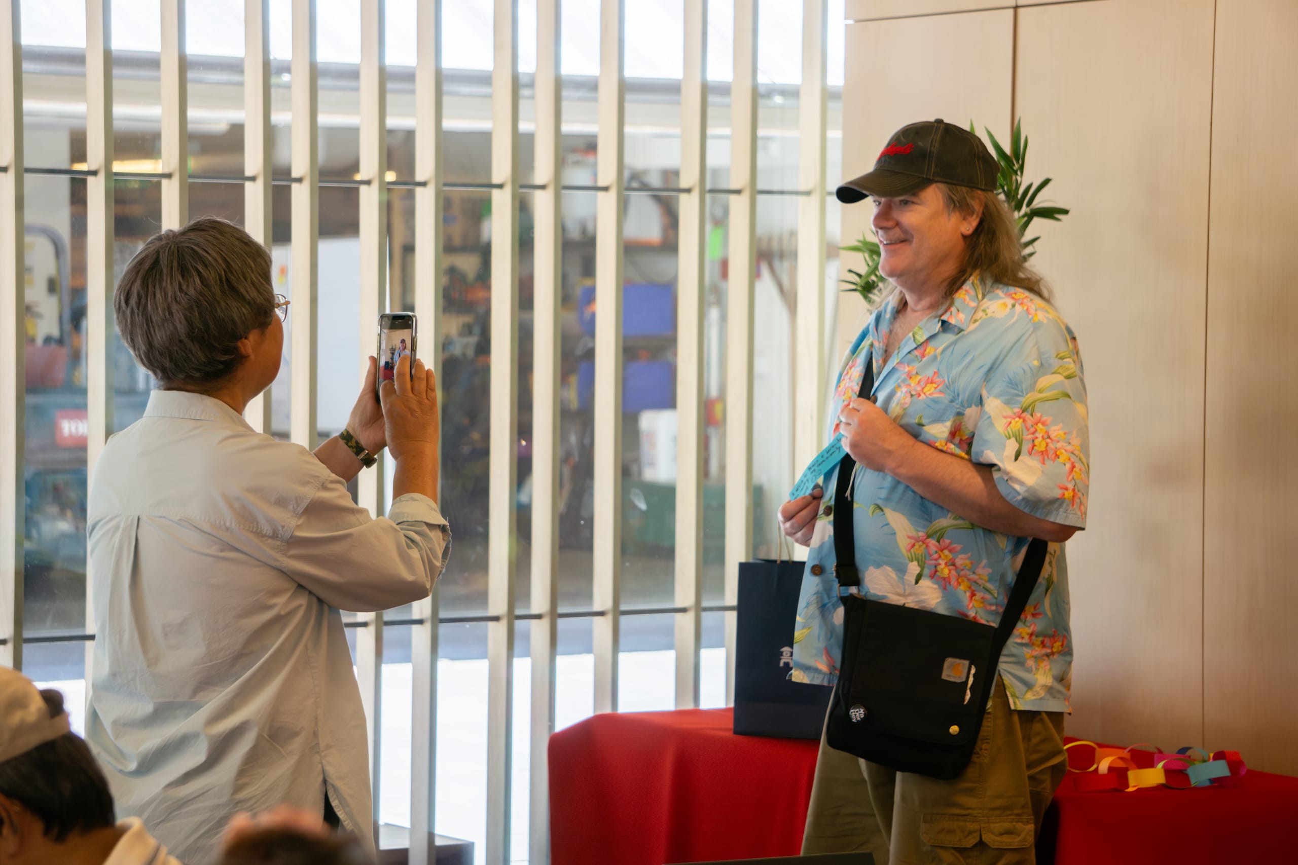 a woman takes a photo of a guest holding their tanzaku