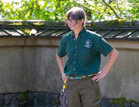 A woman smiles with her hands on her hips
