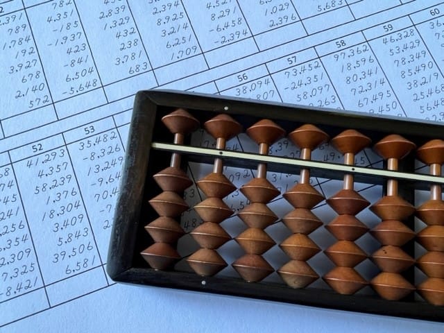 An abacus placed on top of a sheet of financial information