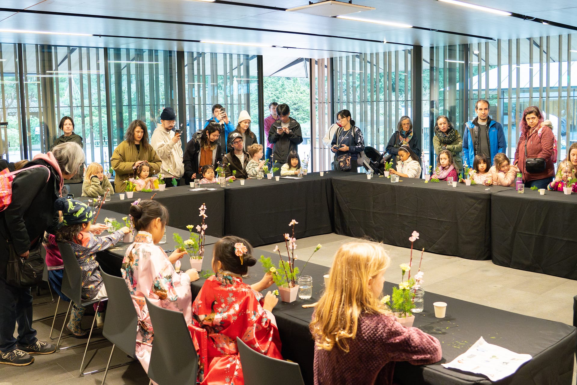 people gathered around a table doing floral arrangements