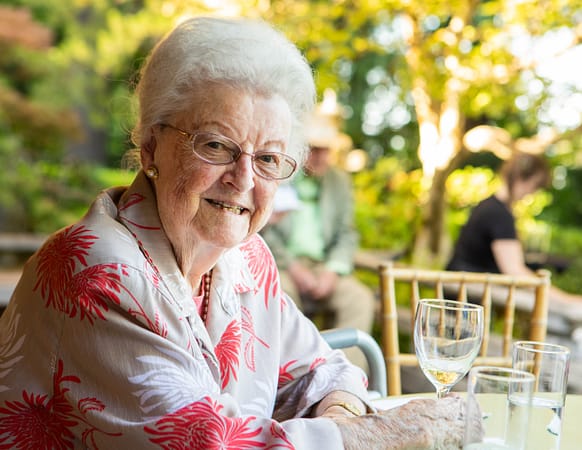 Maggie Drake sitting at a table, smiling.