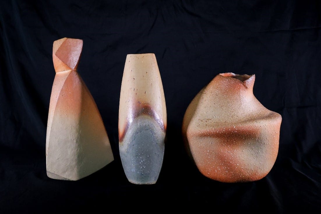 Bizen style pottery in front of a black background.