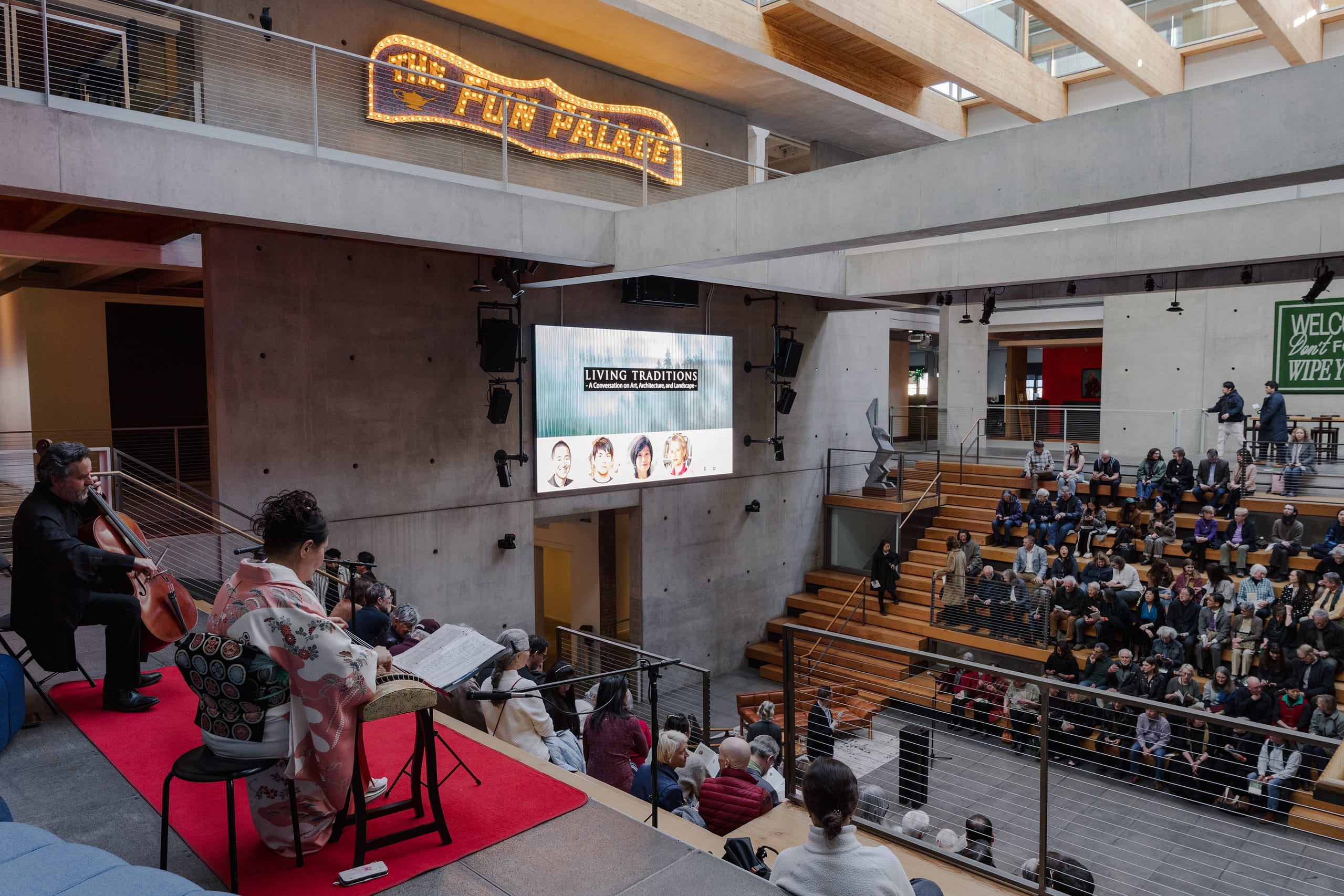 An atrium with people listening to a speaker