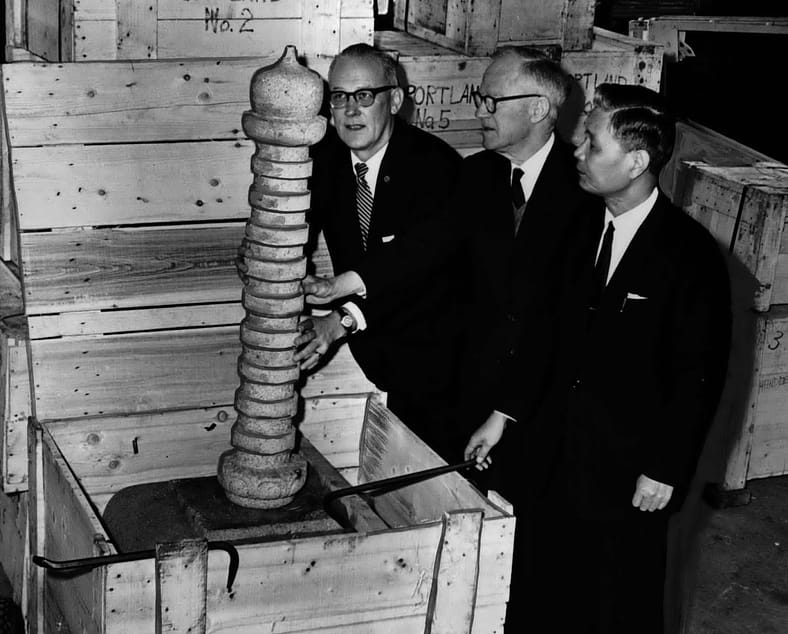 The Mayor of Portland unboxing the top of a stone lantern.