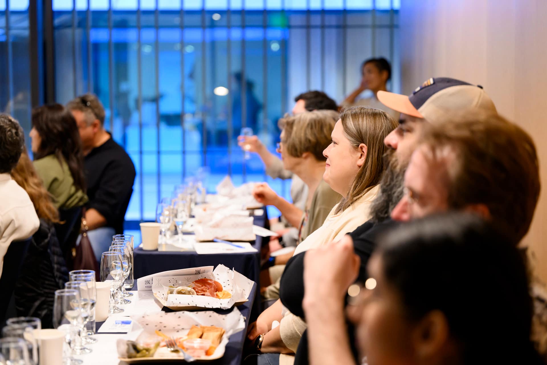 people at a table with light bites and sake glasses