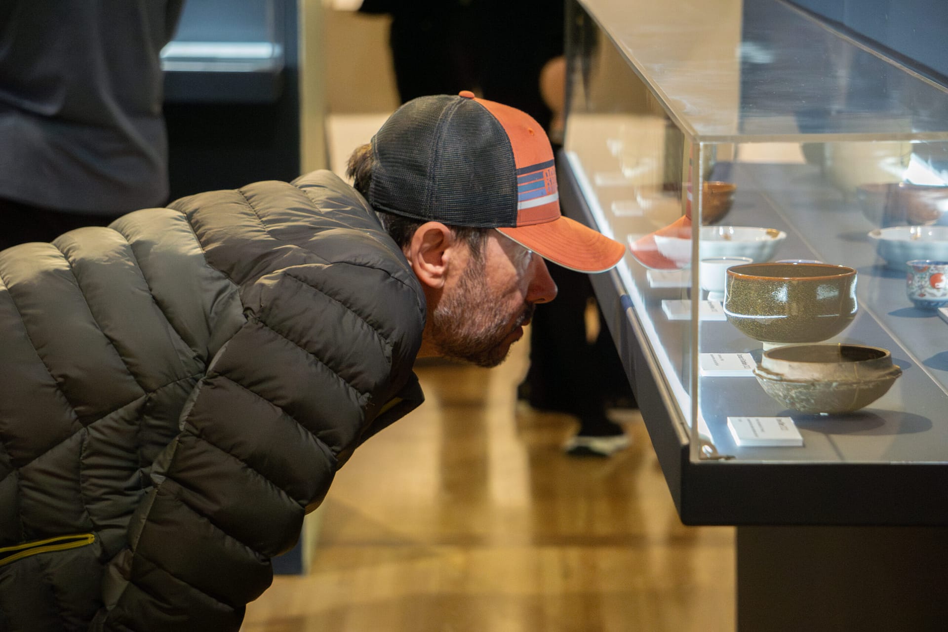 man leans in to get close look at art