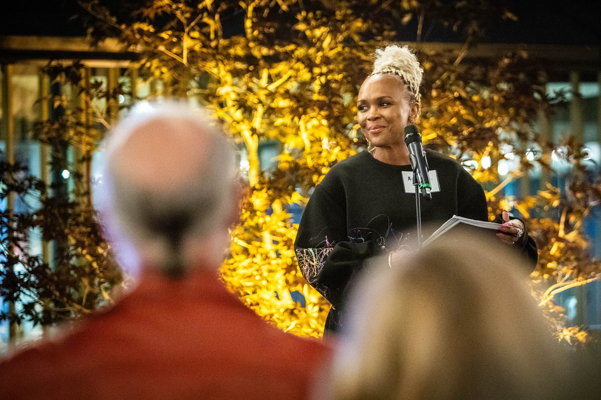 woman standing on stage in front of a microphone