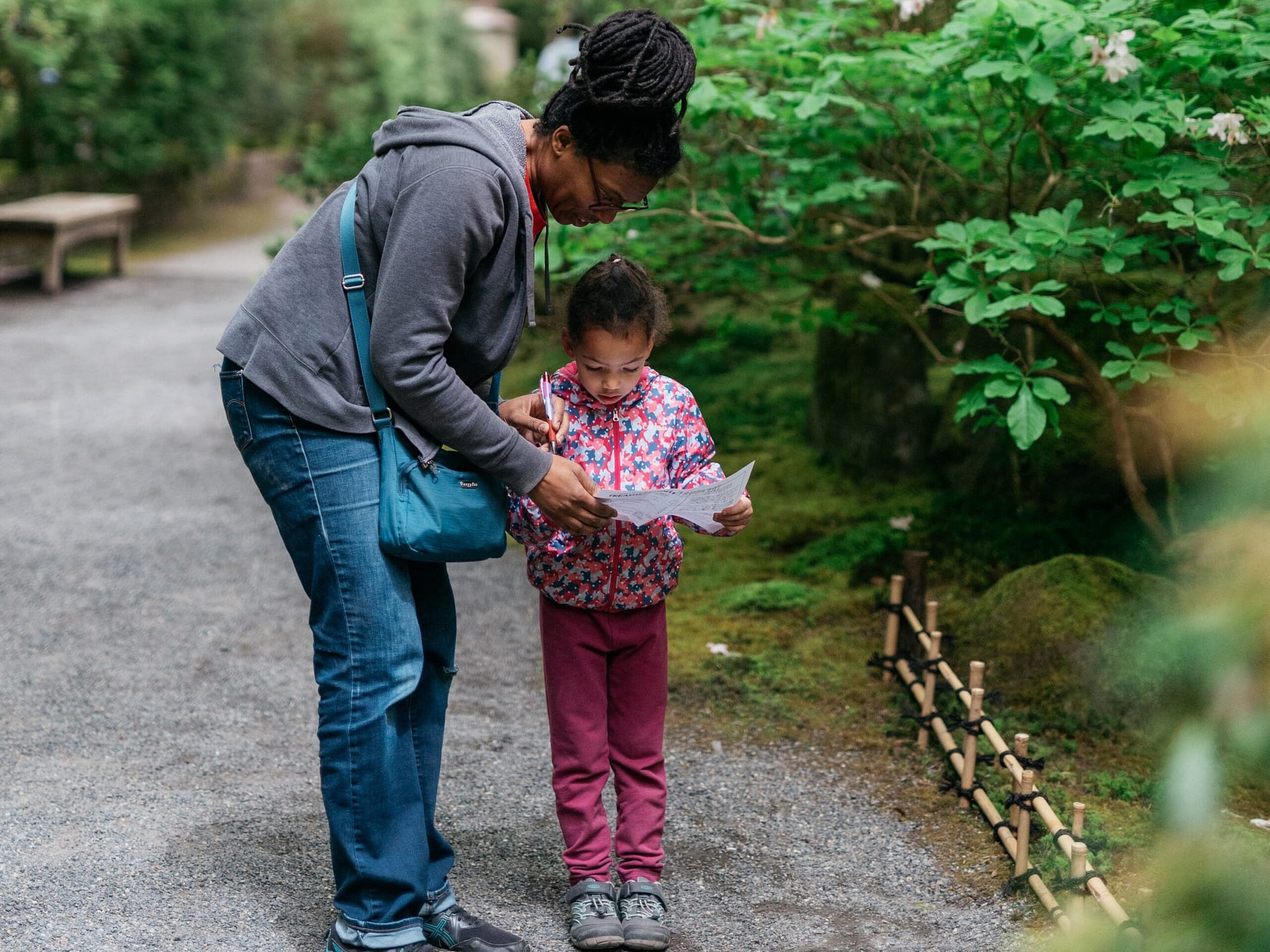 mother and daughter looking over a map in a garden