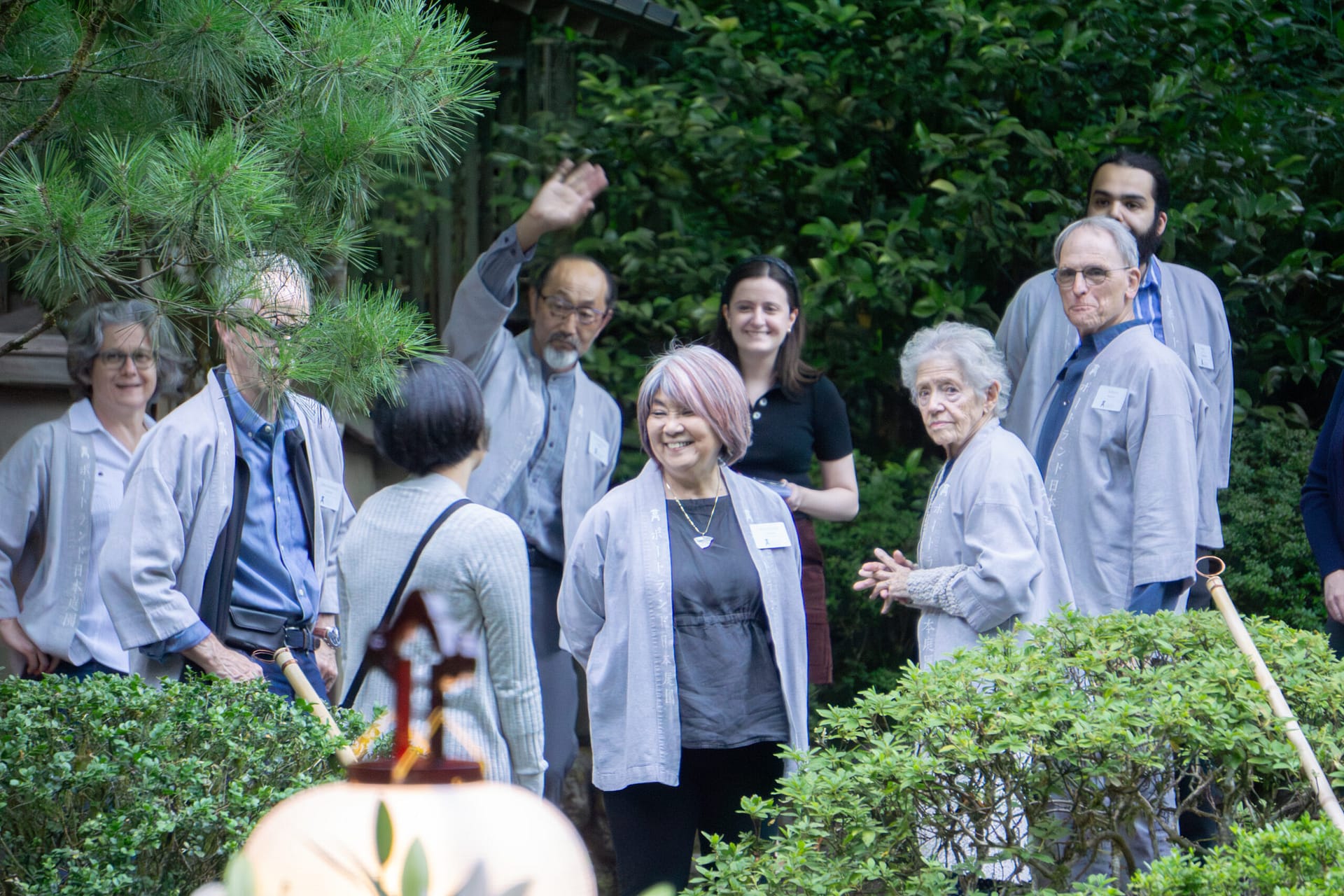 A group of volunteers wearing happi coats enjoying each other's company.