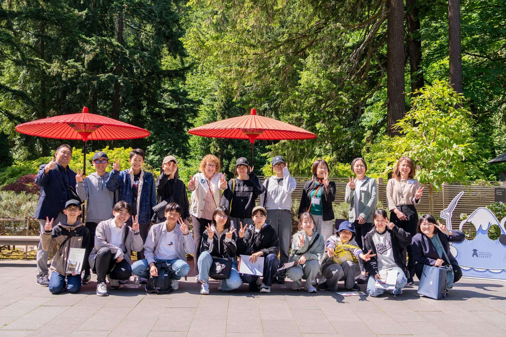 A group of students pose for a camera in a garden