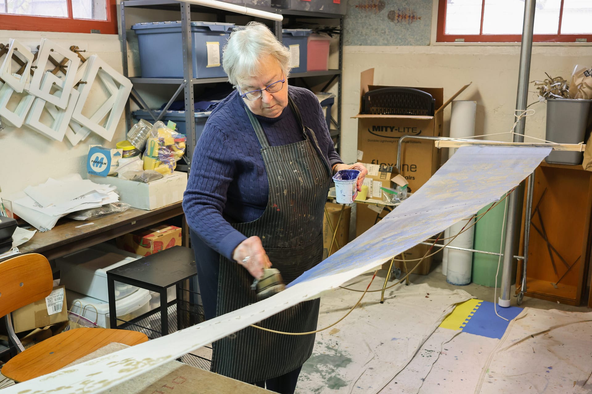 a woman brushes indigo onto fabric
