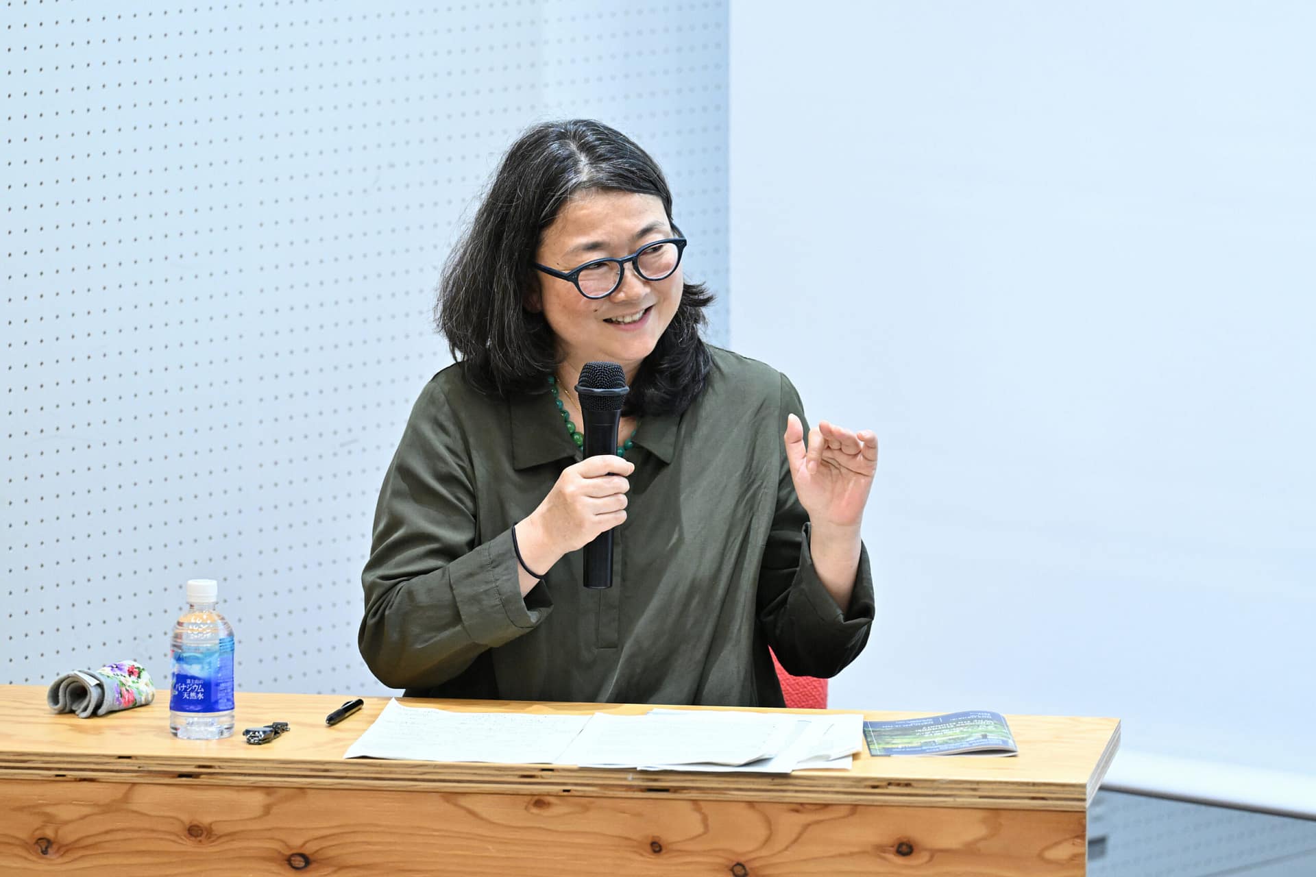 a seated woman speaking into a microphone