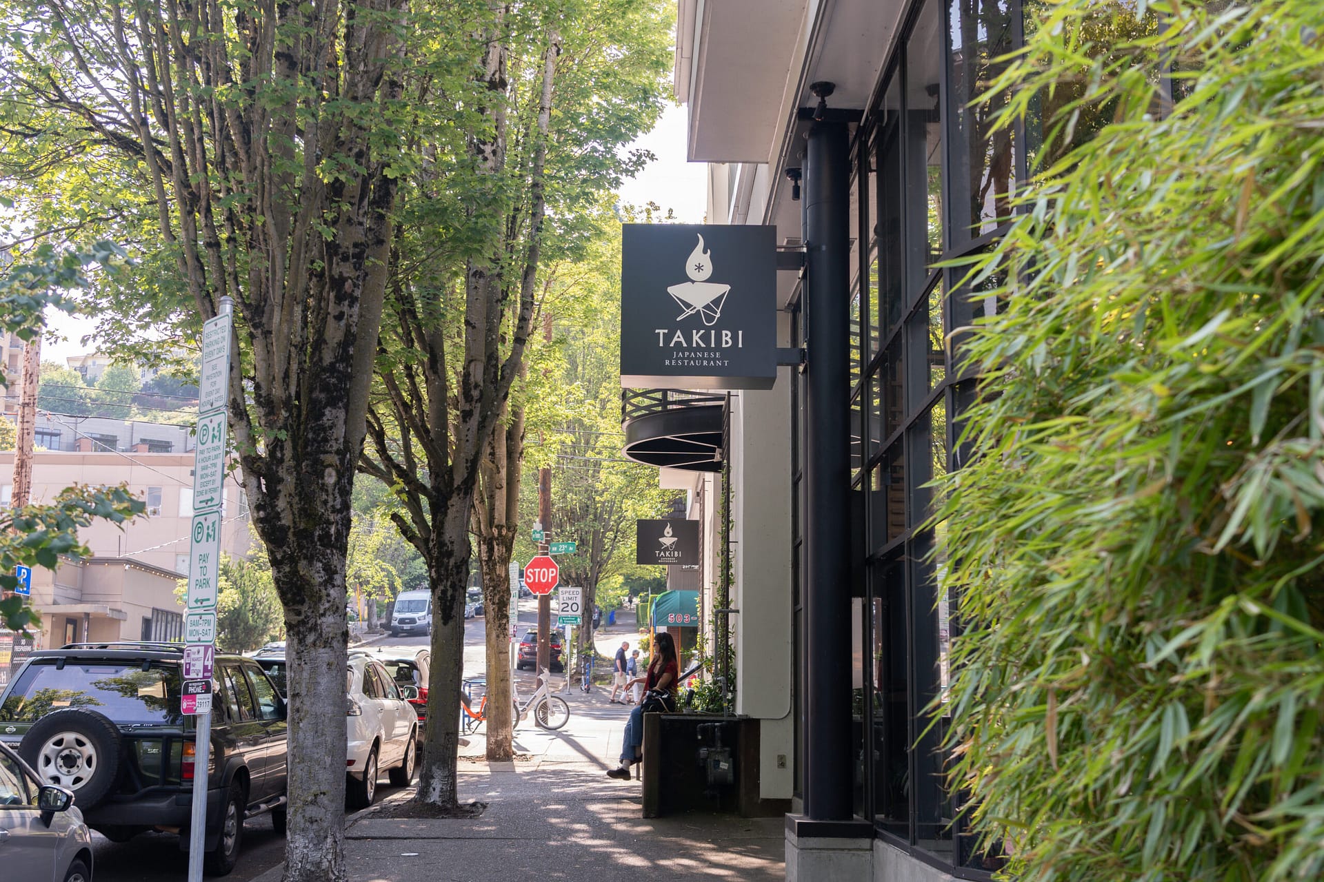 a tree-lined sidewalk outside a restaurant