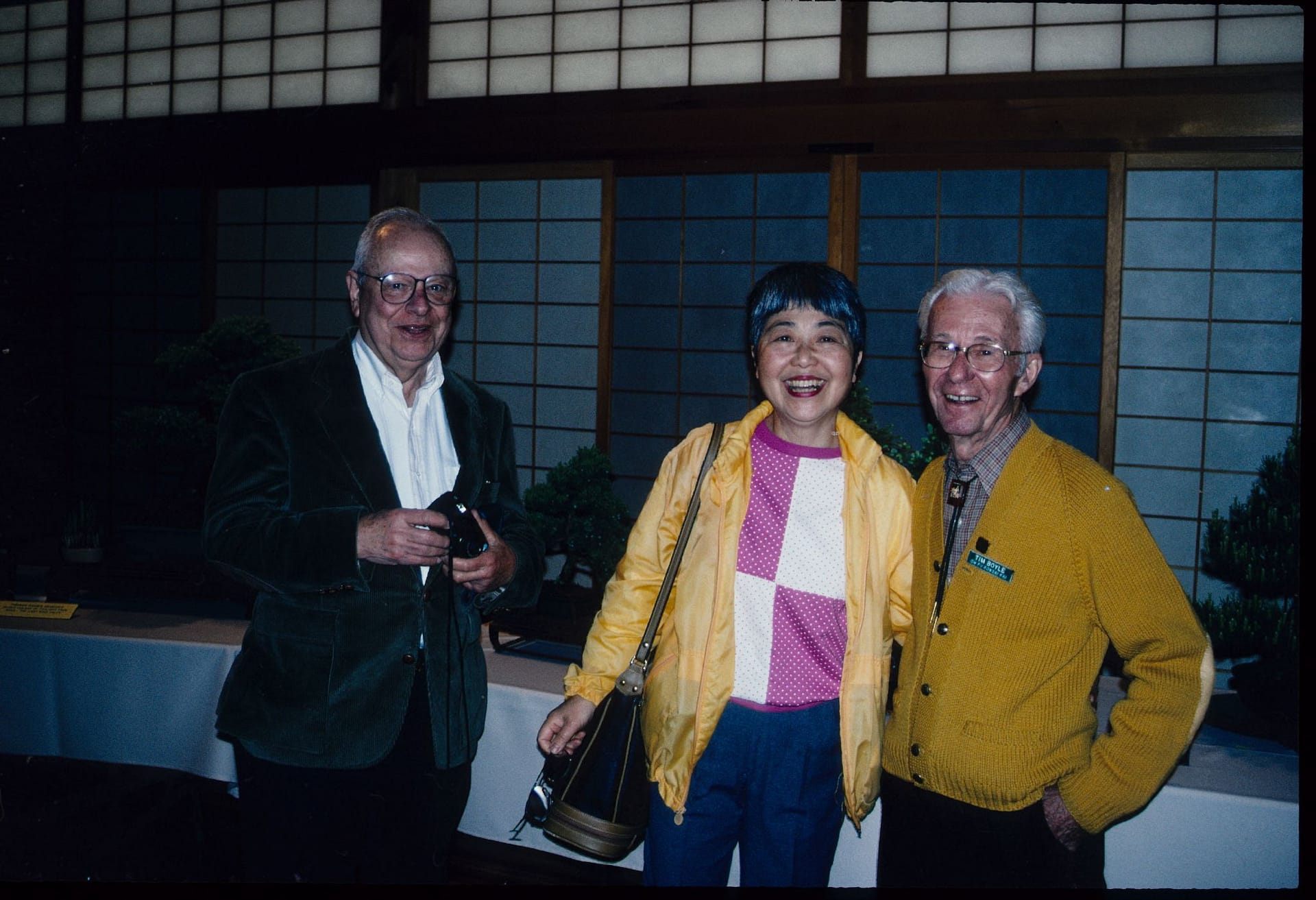 three people smiling for a camera